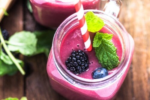 A glass of red berry smoothie.
