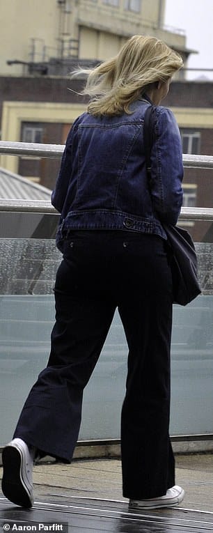 Style: She added a pair of loose-fitting black trousers and white trainers, while she carried her essentials in a black leather handbag