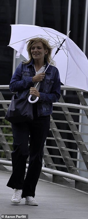 Chilly: The actress, 41, who plays Leanne Battersby, shielded herself with a large white umbrella as she took a break from filming