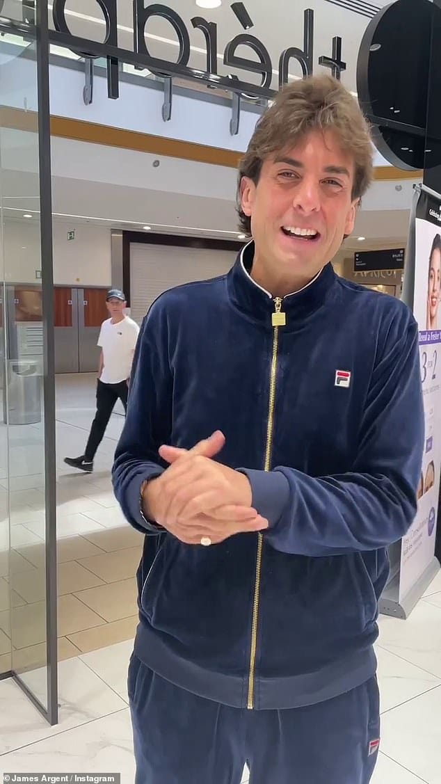 Stylish: James slipped on a navy zip-up jumper, with matching velvet tracksuit bottoms and grey trainers